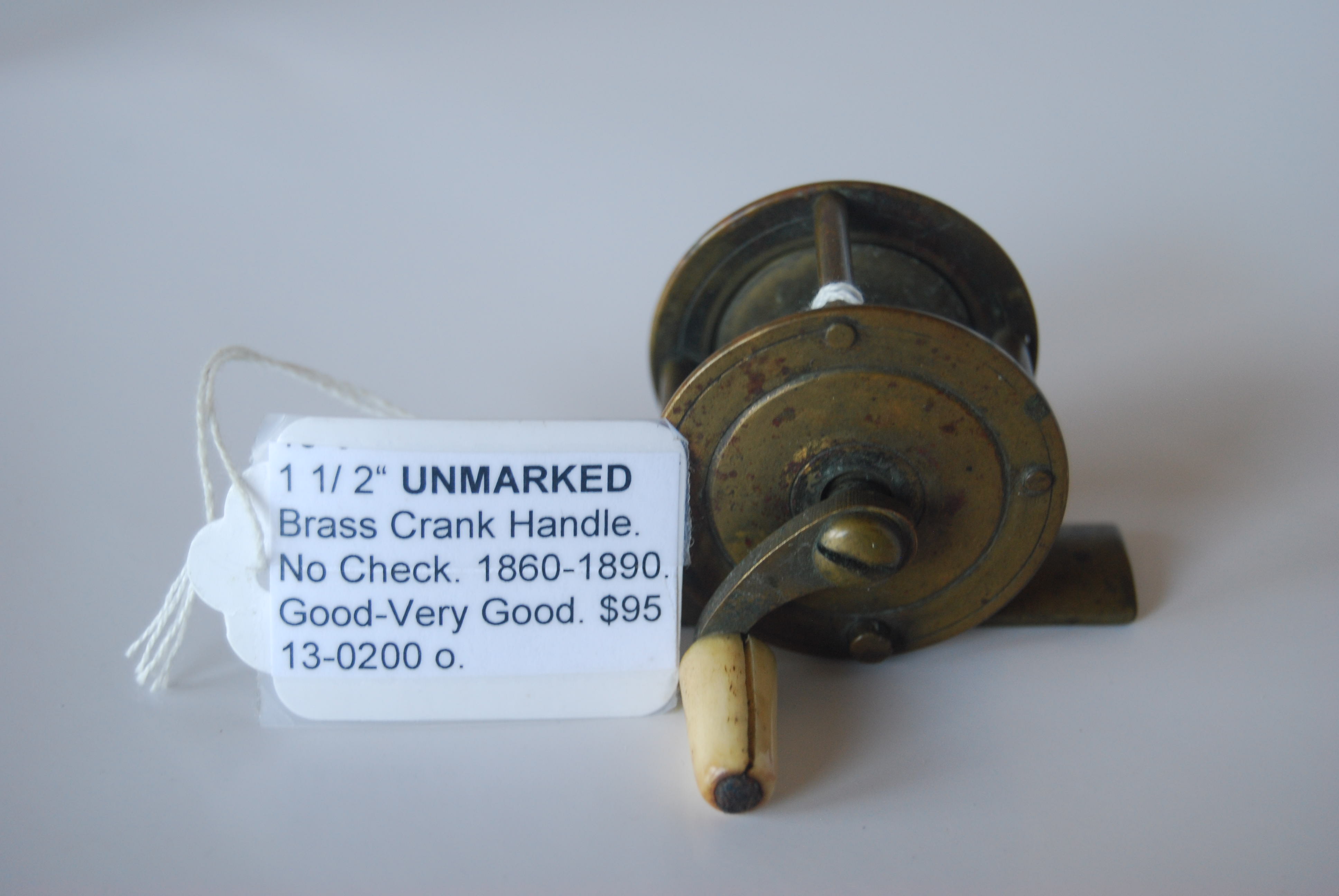 1 1/2” UNMARKED Brass Crank-handle reel. 7/8 in. pillars; No Check; White  Bone knob on curved crank handle; Circa 1860-1890. 2 3/8 oz.